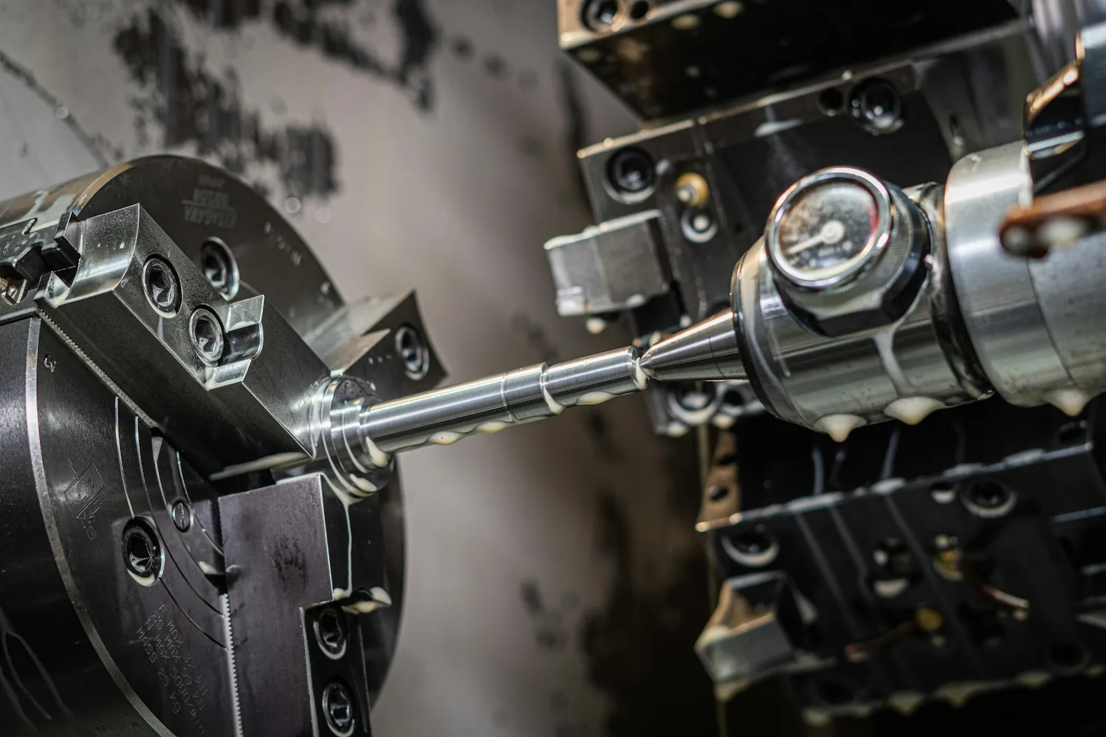 CNC lathe machining a metal shaft on a production floor